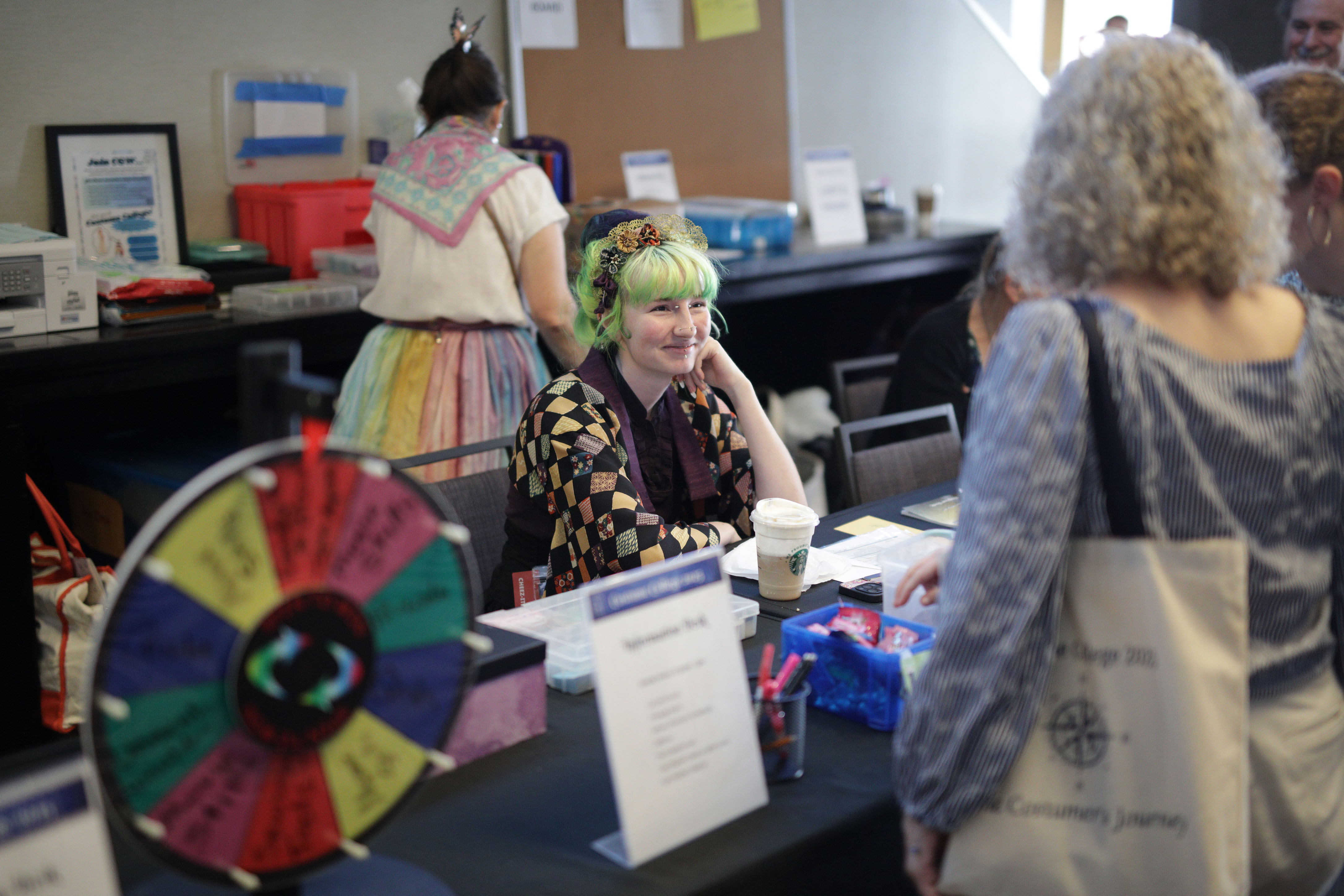 a photograph of Costume College 2026 staff members sitting at the information desk